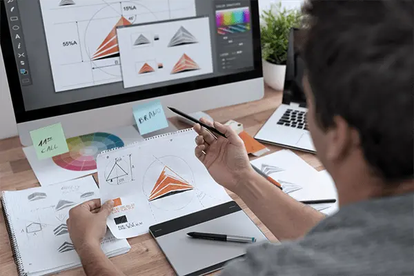 男性がパソコンでデザイン制作を行なっている様子