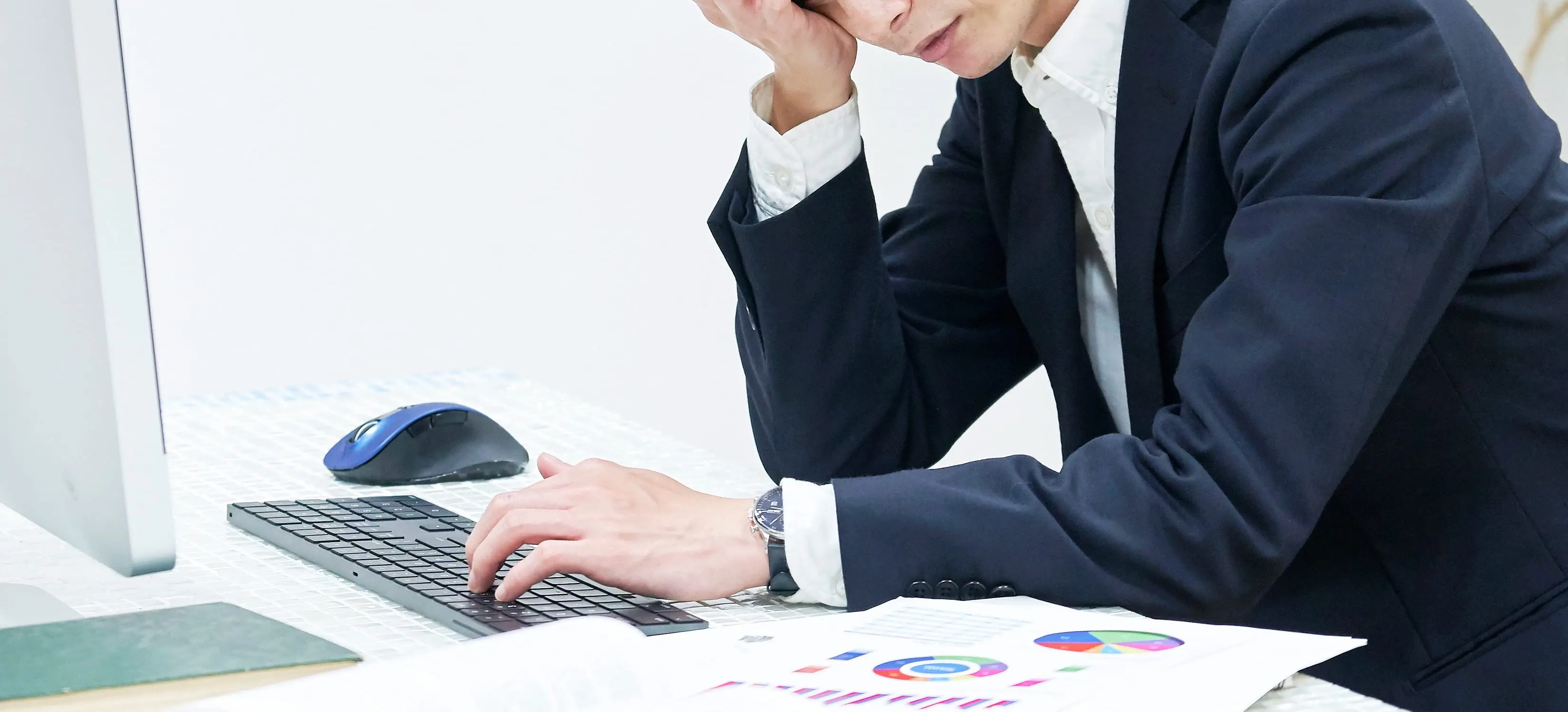 男性がパソコンを前にして頭を抱えている様子